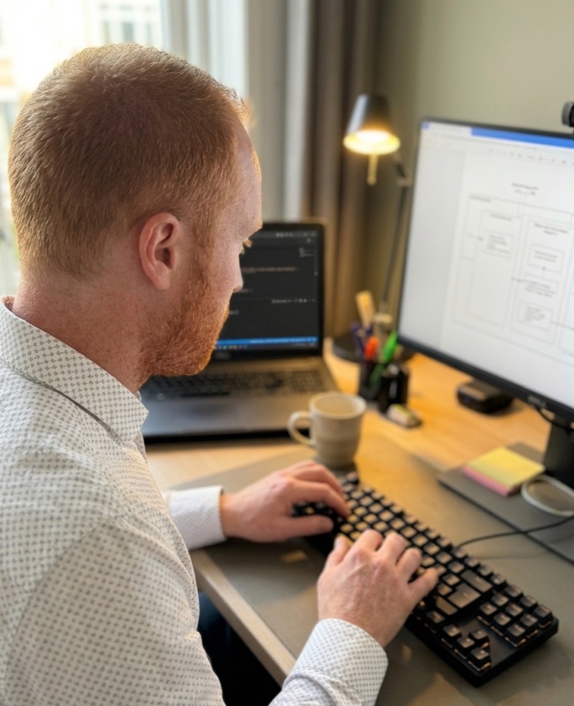 Een specialist van Layer 8 werkt aan een architectuurschets op zijn werkplek